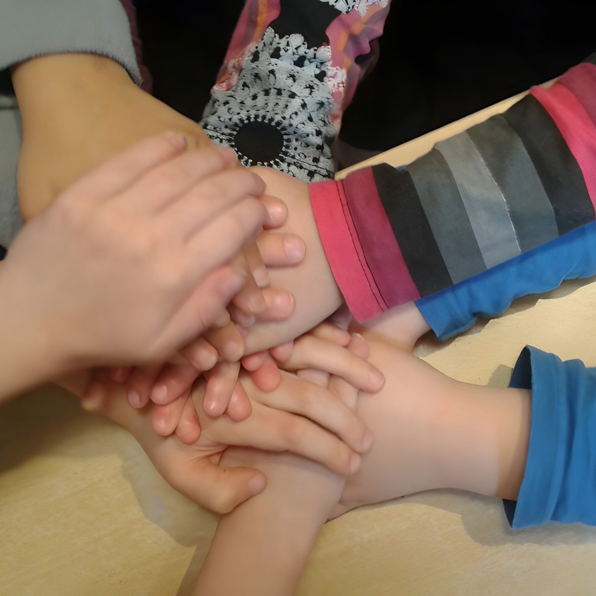 Verschiedene Hände von Kindern, die übereinander gestapelt sind.