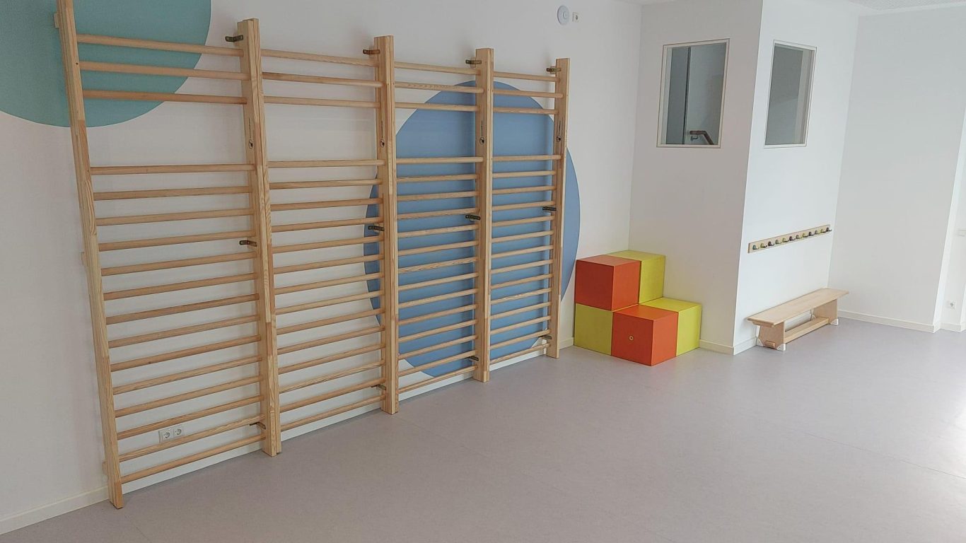 Sprossenwänd in einem Raum mit bunten Schaumstoffblöcken und einer bunten Wand.