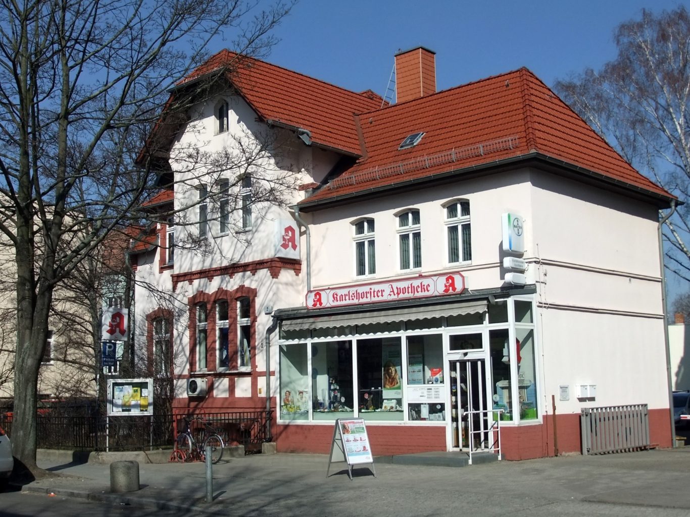 Ein Foto der Kita vor dem Umbau, noch mit dem alten Windfang und dem Apothekenschild.